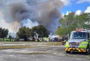 Casi 50 unidades de bomberos combaten incendio de máximo nivel en depósito de Miami