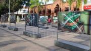 Dos adultos mayores pintarrajean fotografías expuestas en Manzana Uno