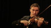 Un solista de violín y piano con la Orquesta Sinfónica