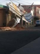 Bomberos Voluntarios socorren a una mujer después del desplome de una pared