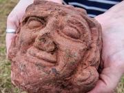 Una joven se sorprende al encontrar en una excavación una cabeza humana tallada mirándola fijamente