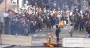 Manifestantes destruyen la puerta de un edificio para levantar barricada cerca de la plaza Murillo